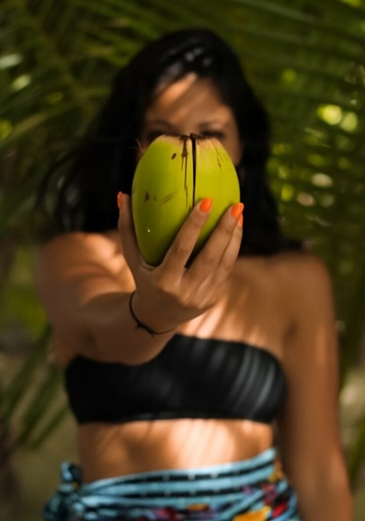 Woman holding mango for salsa recipe.
