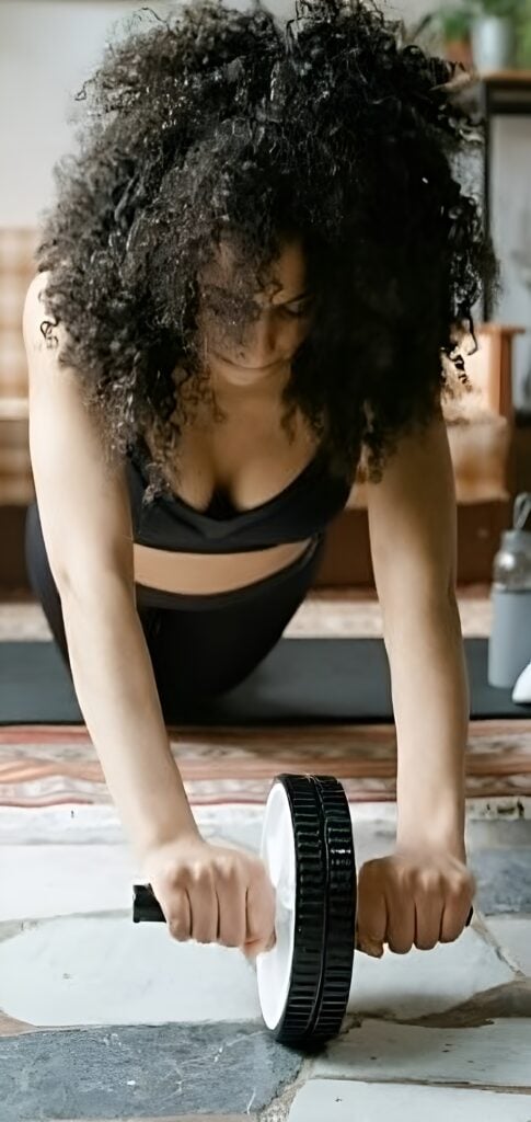 Woman exercising with an ab roller to strengthen her stomach area.