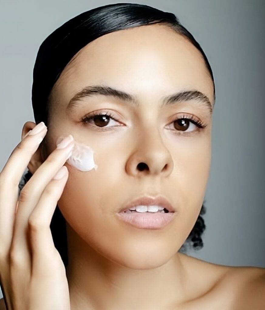 Woman applying homemade face cream recipes under her eyes.